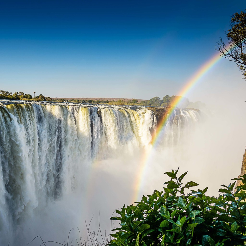 Victoria Falls in Zimbabwe met regenboog boven de waterval, tijdens een groepsrondreis Zimbabwe.