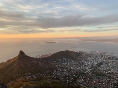 Uitzicht vanaf de Tafelberg op Kaapstad en de Atlantische Oceaan bij zonsondergang.