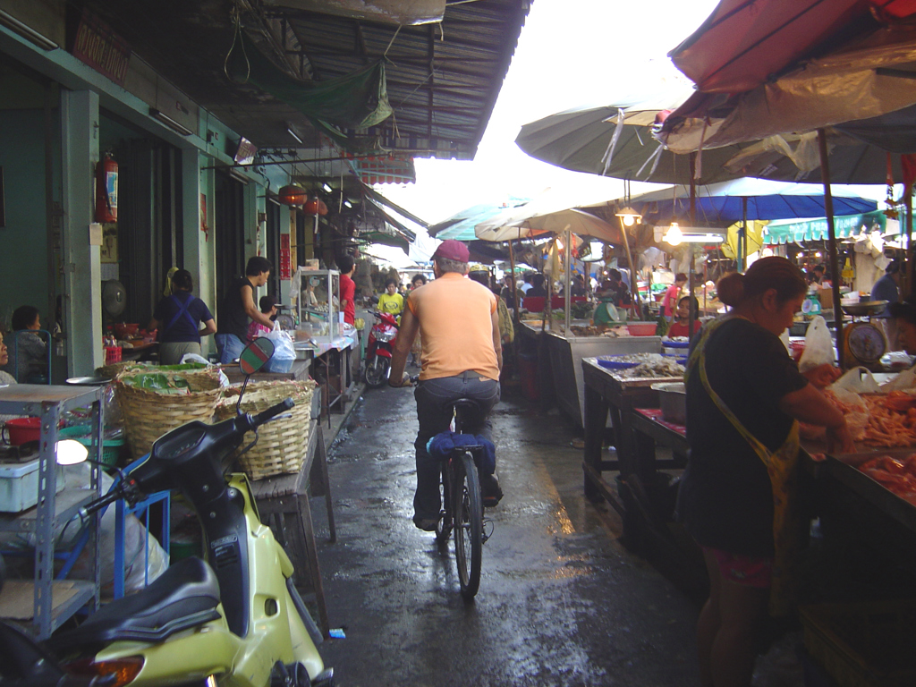 Fietser tussen kraampjes op een drukke markt in Thailand tijdens de groepsrondreis Thailand Avontuur.