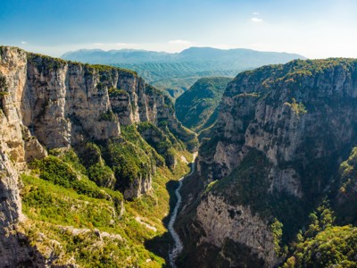 Uitzicht over de Vikos-kloof in Noord-Griekenland met steile rotswanden en een rivier in de vallei.