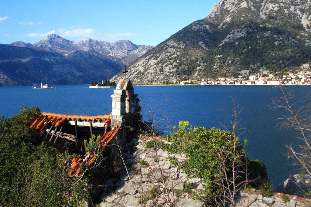 Uitzicht over de Baai van Kotor in Montenegro, met bergen, blauw water en een dorp aan de kust.