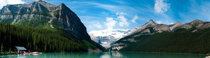 Uitzicht op Lake Louise met turquoise water, dennenbossen en besneeuwde bergen in West-Canada.
