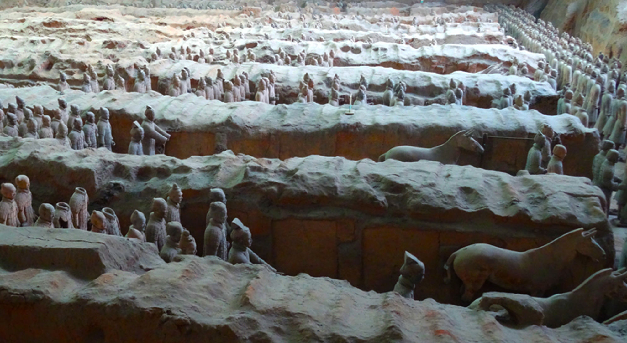 Terracottaleger in China Terracottaleger in Xi’an met rijen kleisoldaten en paarden in opgegraven kuilen.