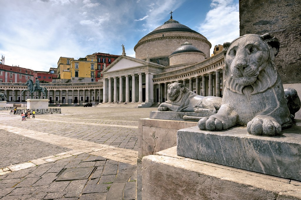 Piazza del Plebiscito in Napels met marmeren leeuwenbeelden en de koepel van de Basilica di San Francesco di Paola.