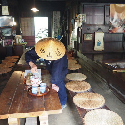Traditioneel theehuis in Japan met gastheer die thee serveert, tijdens groepsrondreis Japan hoogtepunten.