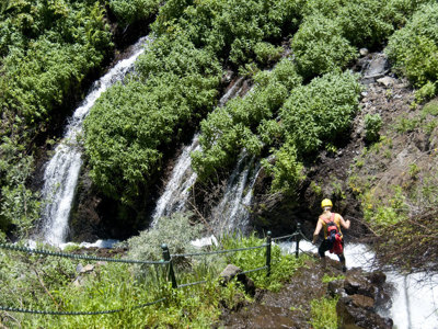 Wandelaar bij waterval in groen berglandschap op Tenerife tijdens 10-daagse wandelvakantie Tenerife & La Palma.