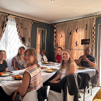 Samen eten bij een lokale familie in Zuid-Afrika, met een gedekte tafel in huiselijke sfeer.