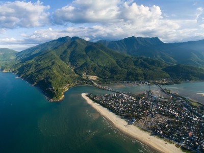 de kust bij Da Nang in Vietnam, met strand, stad en groene bergen.