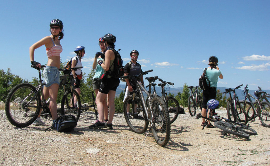 Gezin met mountainbikes pauzeert tijdens een fietstocht in de bergen van Kroatië en Montenegro.