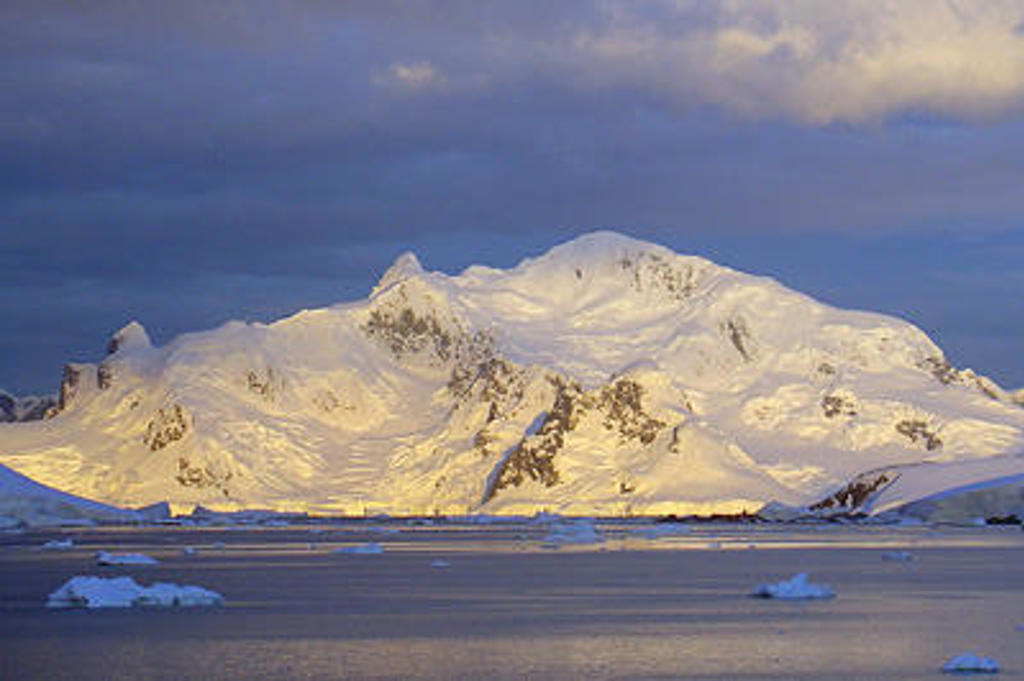Besneeuwde bergen en drijvend ijs in Antarctica tijdens de expeditie Crossing the Circle, voorbij de Zuidpoolcirkel.
