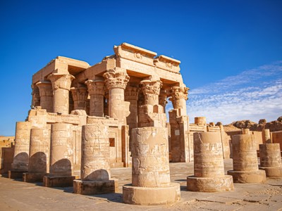Tempel van Philae bij Aswan met zuilen en reliëfs onder een helderblauwe lucht.