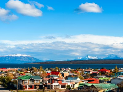 Uitzicht op Ushuaia met kleurrijke daken, het Beaglekanaal en besneeuwde Andesbergen in Patagonië.