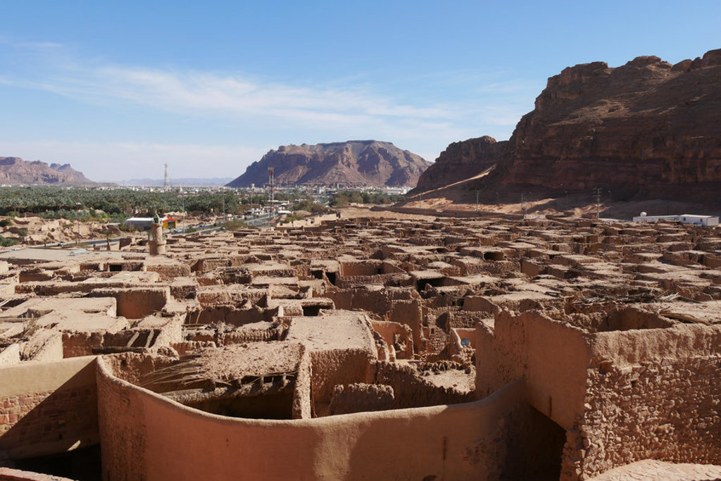 Uitzicht over de lemen ruïnes van Al-Ula met rotsformaties op de achtergrond tijdens een groepsrondreis Saoedi-Arabië.