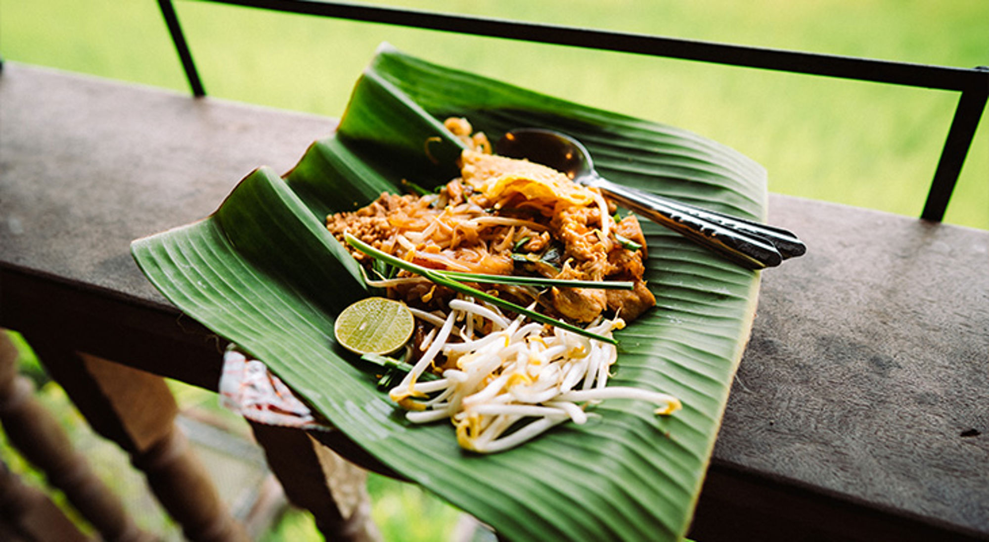 Thaise keuken Pad Thai geserveerd op een bananenblad met limoen en taugé.