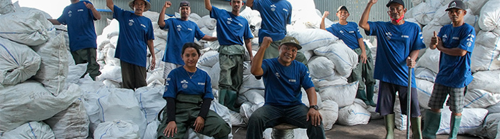 Team bij afvalbarrière op Bali poseert voor zakken met ingezameld afval, 4.611 kilo tegengehouden.