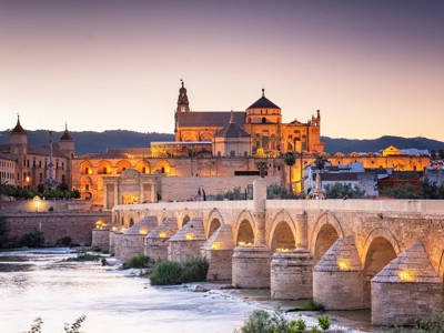 Verlichte Romeinse brug en Mezquita-kathedraal van Córdoba bij zonsondergang, tijdens familiereis Spanje & Portugal.