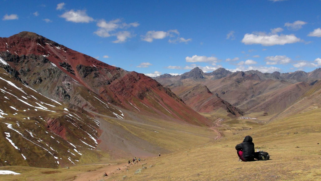 Wandelaar kijkt uit over de kleurrijke Andesbergen in Peru tijdens een familiereis.