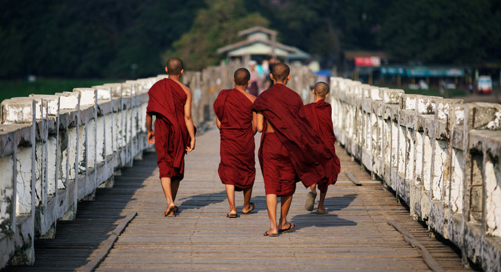 Monniken lopen over de U Bein-brug bij Mandalay tijdens een groepsrondreis Myanmar.