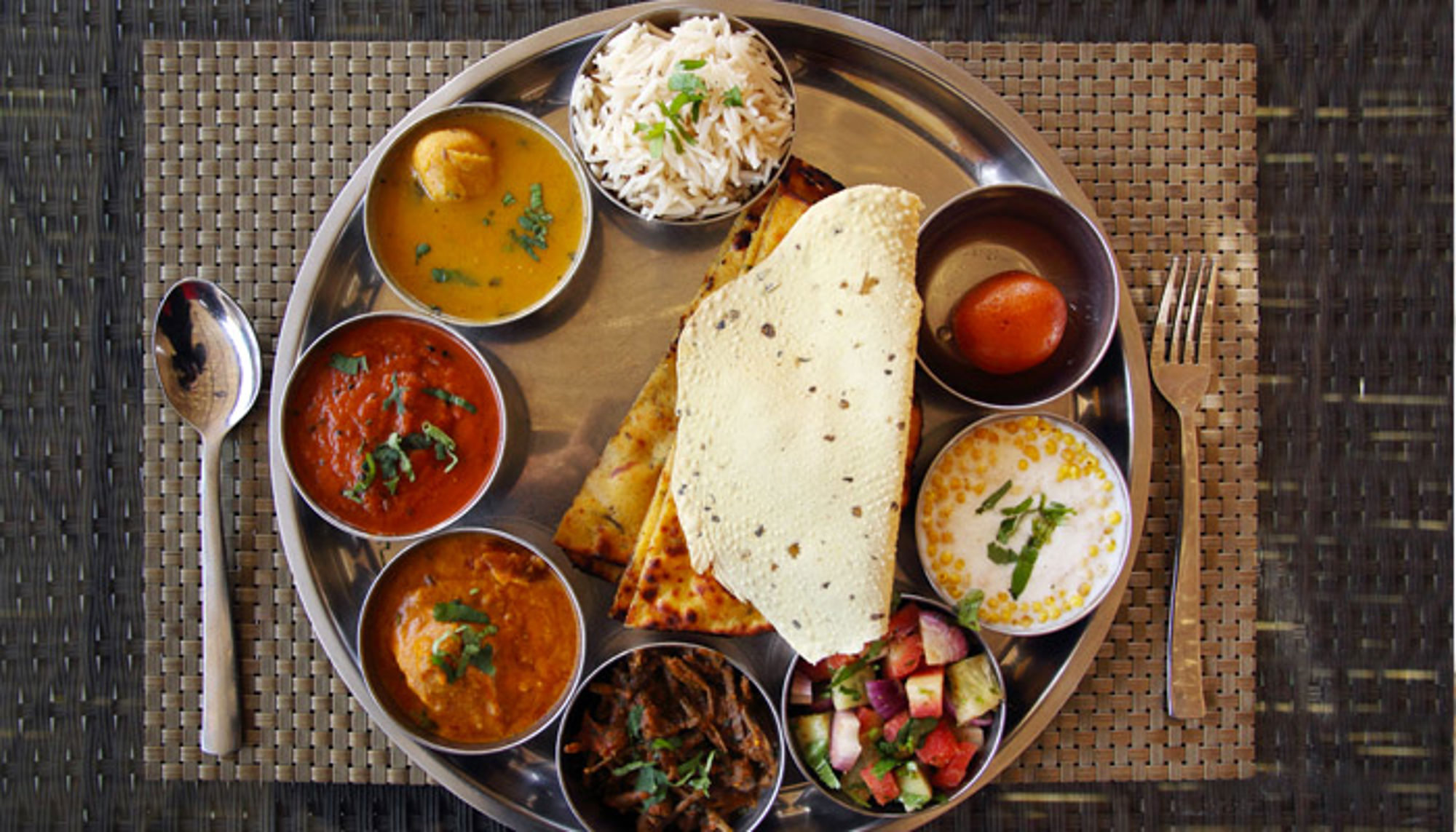 thali gerecht in india Indiase thali met curry’s, rijst, naan, raita en salade op een metalen dienblad.
