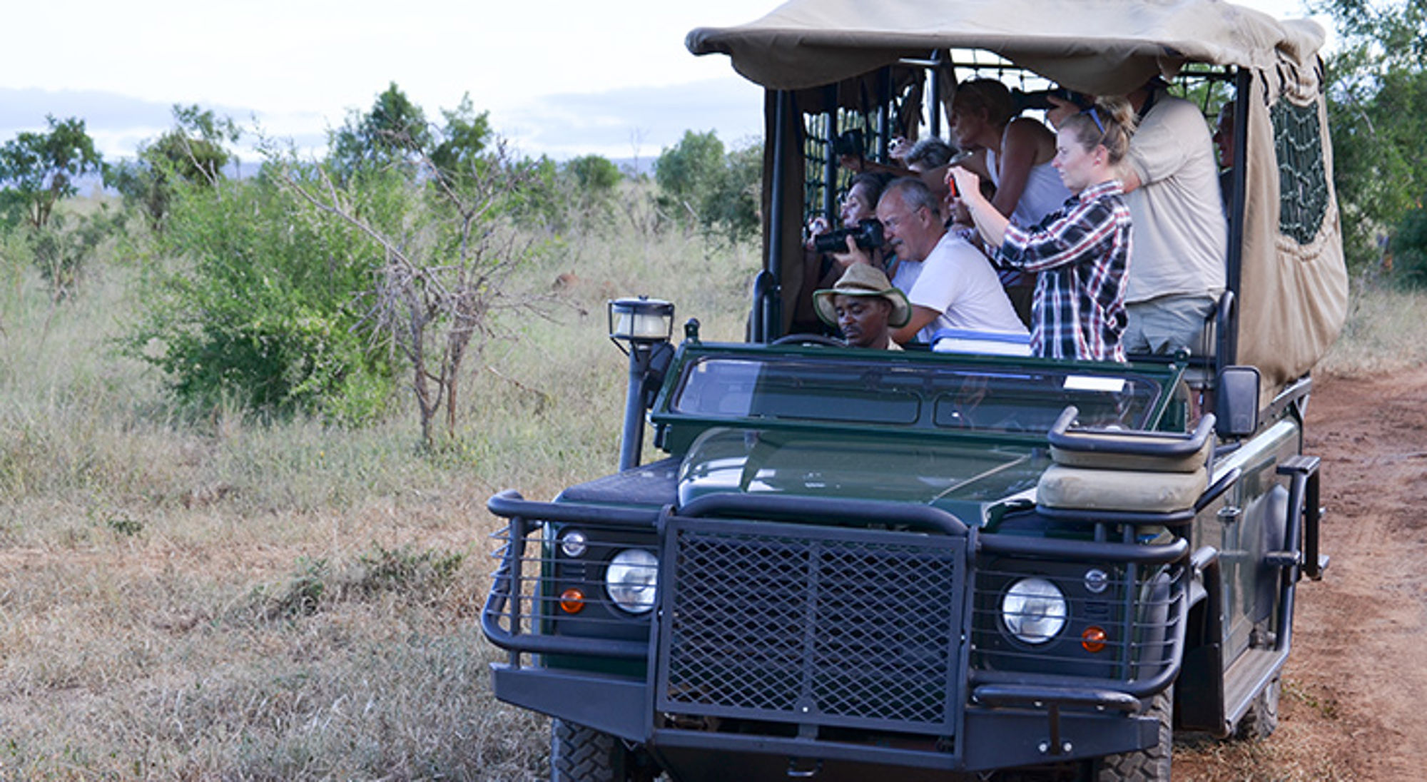 Jeep in Mlilwana Nationaal Park, Swaziland Safari-jeep met reizigers die wild fotograferen in de savanne.