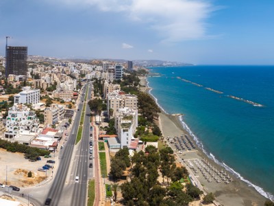 Uitzicht op de kustlijn van Limassol op Cyprus met strand, boulevard en hoge gebouwen aan zee.