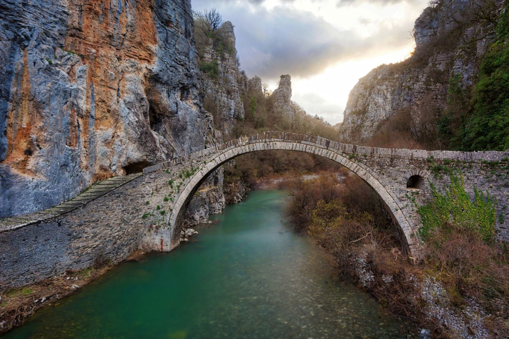 Stenen boogbrug over de Voidomatis-rivier in de Vikos-kloof, Zagori, Griekenland.
