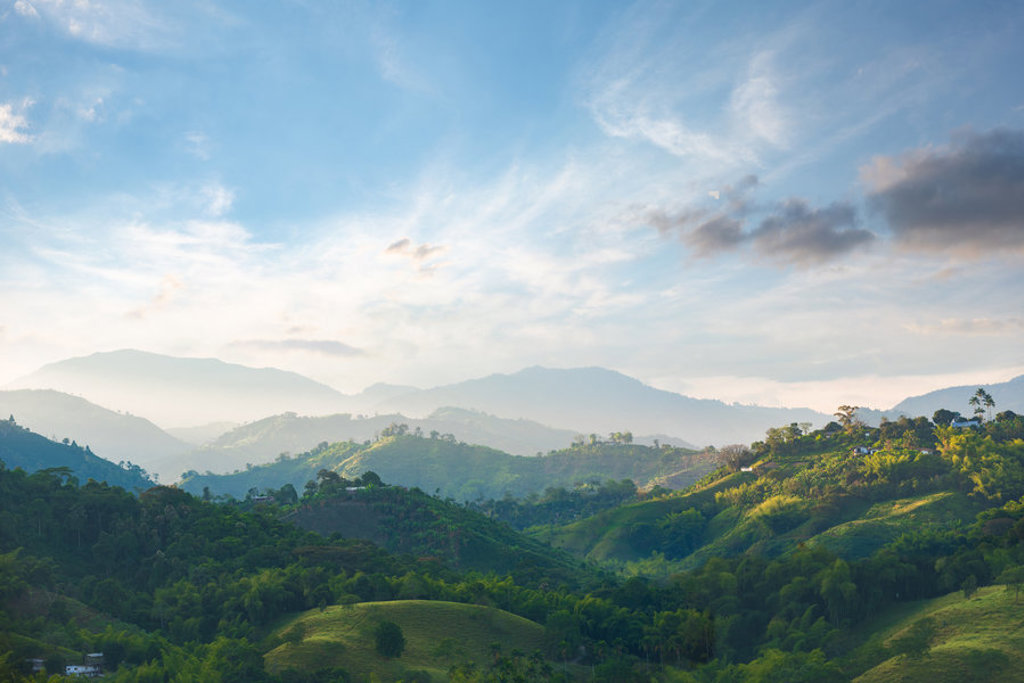 Groene heuvels en bergen in Colombia bij zonsopkomst tijdens een groepsrondreis.