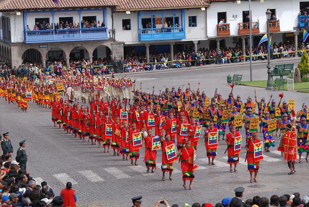 Traditionele optocht met dansers in kleurrijke kleding op het Plaza de Armas in Cusco, Peru.