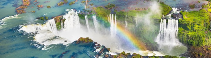 de Iguazú-watervallen bij Foz do Iguaçu, met nevel en regenboog boven het water.