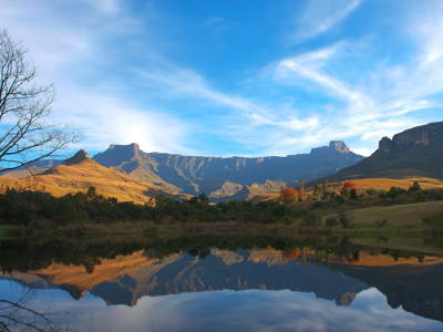 Panorama van de Drakensbergen met weerspiegeling in een rustig meer, op de route Johannesburg - Kaapstad.