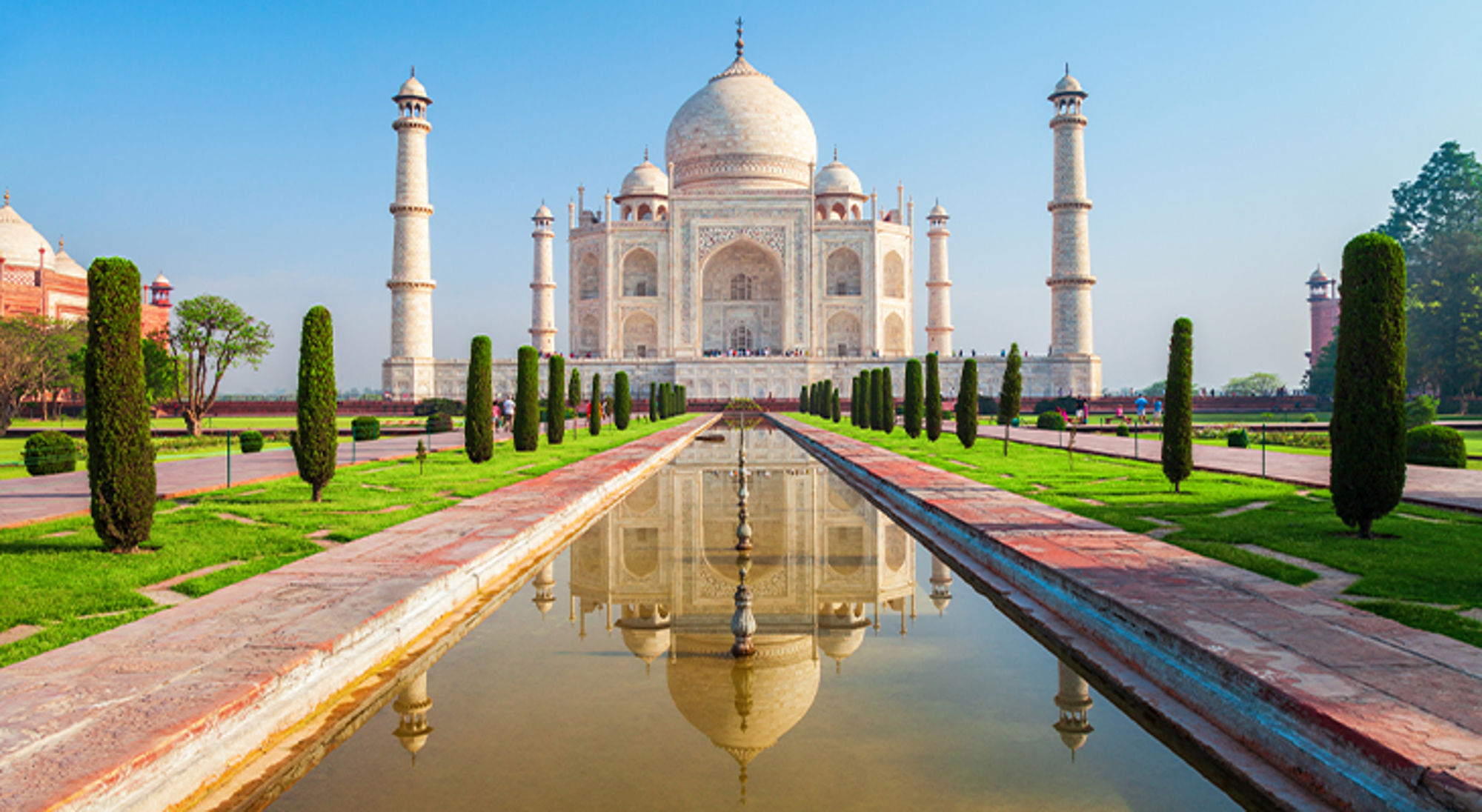 Taj Mahal India - 7 nieuwe wereldwonderen Taj Mahal in Agra met weerspiegeling in de waterpartij en symmetrische tuinen.