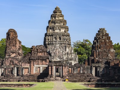 Khmer-tempel Phanom Rung bij Buriram, Thailand, met centrale toren en ruïnes onder blauwe lucht.