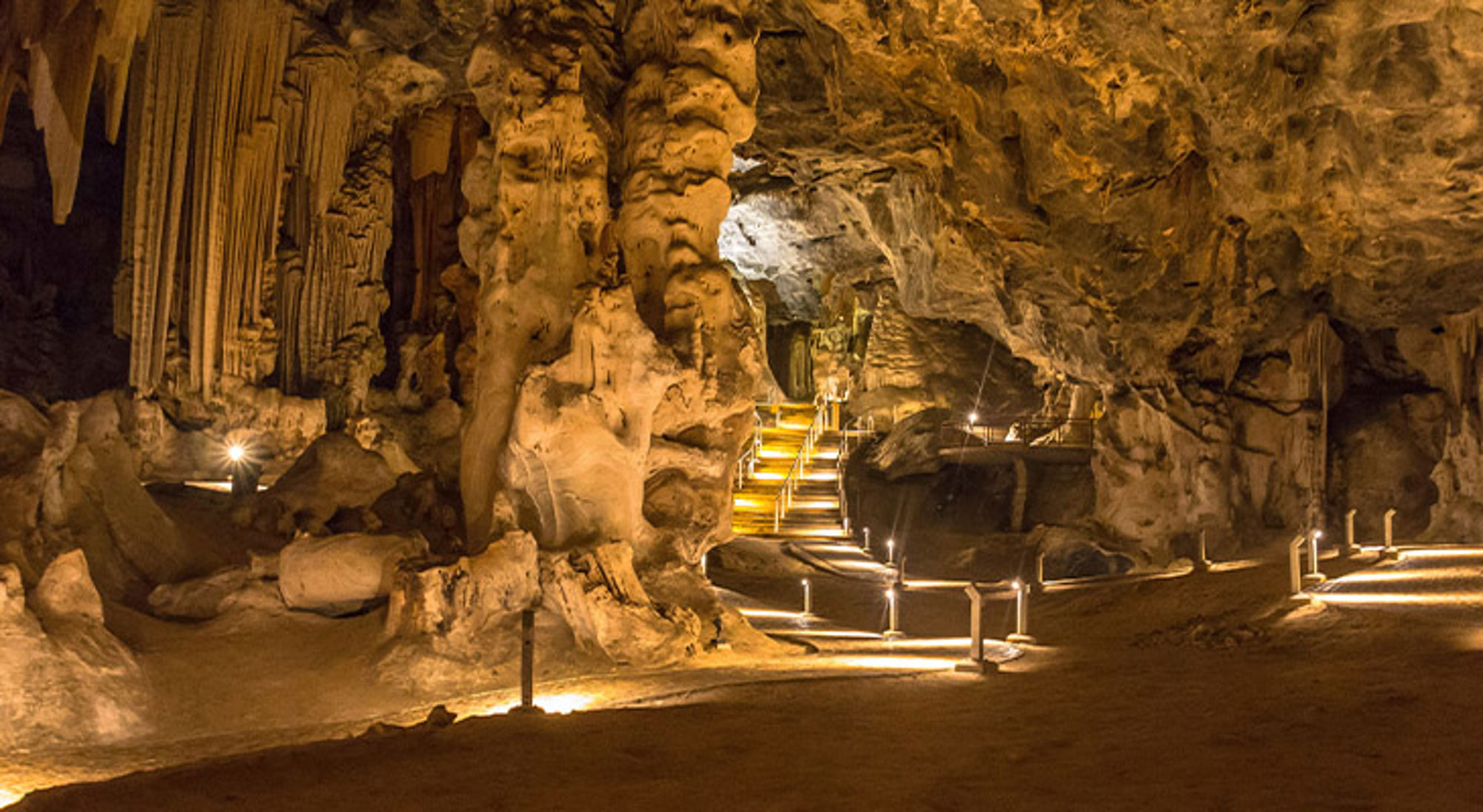 Cango grotten Oudtshoorn Zuid-Afrika Verlichte grot met stalactieten en wandelpad met trappen langs rotsformaties.