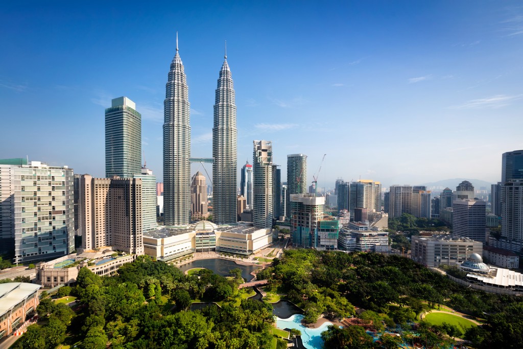 Petronas Twin Towers in Kuala Lumpur, West-Maleisië, met skyline en groen park.