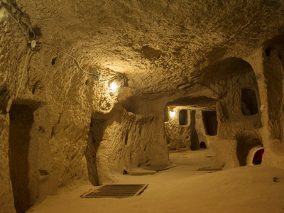 Ondergrondse stad in Cappadocië, Turkije, met uitgehakte gangen en kamers verlicht door lampen.