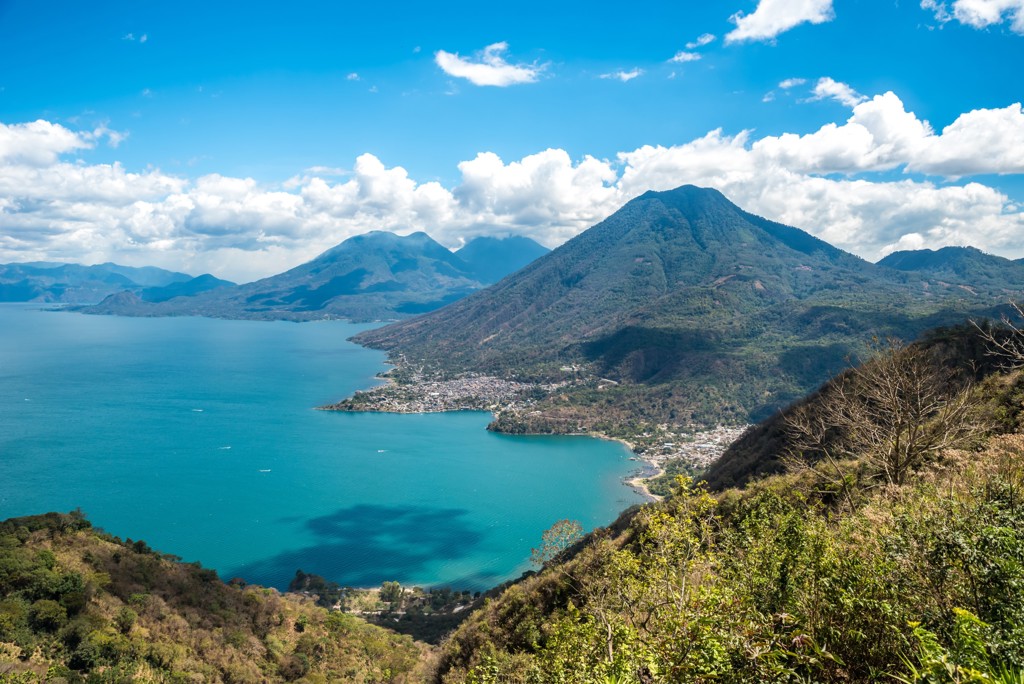 Uitzicht over het Atitlánmeer met vulkanen en dorpjes langs de oever in Guatemala.