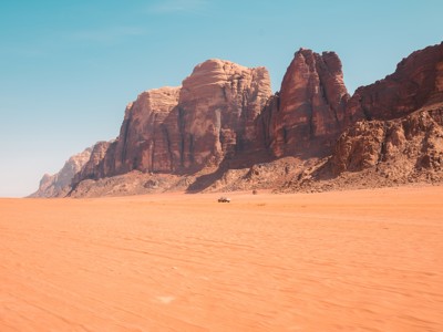 Rode zandvlakte met hoge rotsformaties in Wadi Rum, Jordanië, op de Route Jordanië.