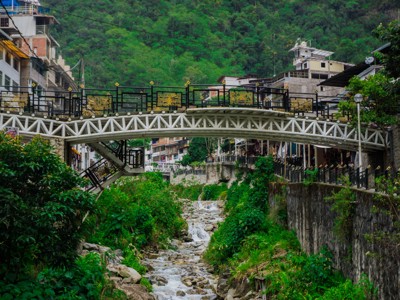 Voetgangersbrug over rivier in Aguas Calientes, op de route Peru incl. Amazone.