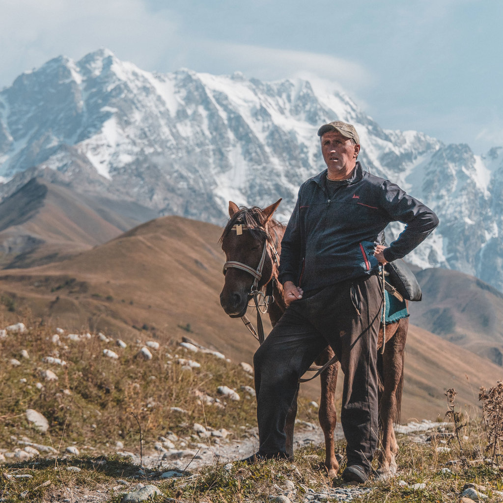 Man met paard in de bergen van Armenië en Georgië tijdens een groepsrondreis.