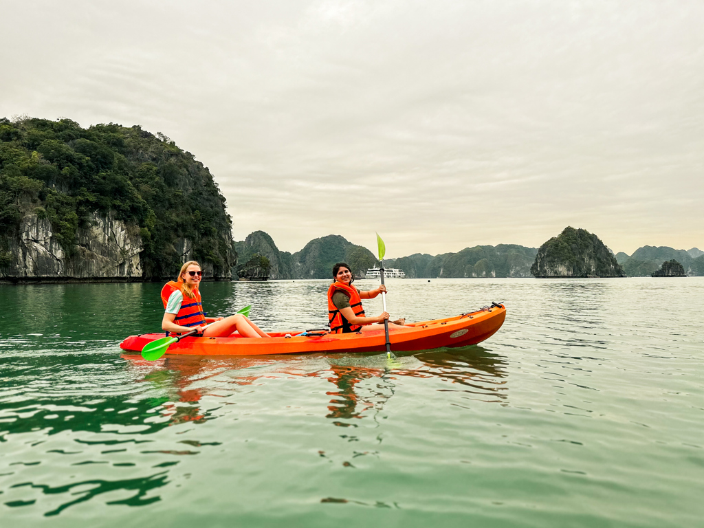 Kajakken tussen kalkstenen rotsen in Ha Long Bay tijdens een 22-35ers reis Vietnam.