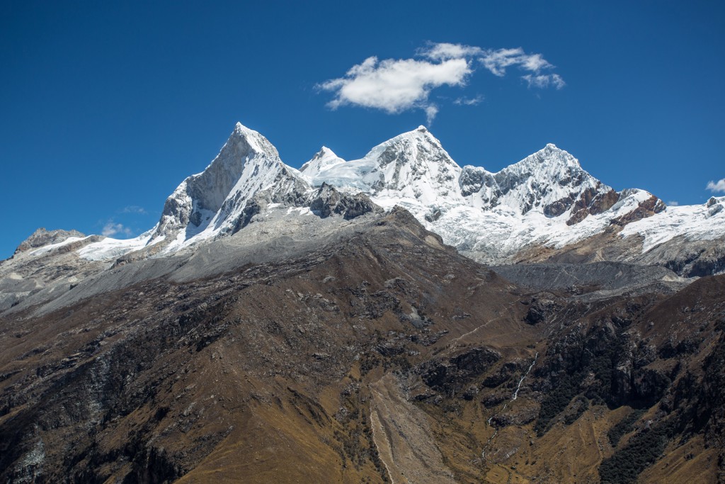 Besneeuwde bergtoppen in de Cordillera Blanca in Noord-Peru onder een helderblauwe lucht.