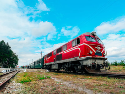 Rode locomotief van de Oriënt Express naar Istanbul op het spoor onder een blauwe lucht.