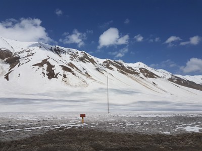 Besneeuwde bergtoppen in de Kaukasus in Georgië onder een helderblauwe lucht.