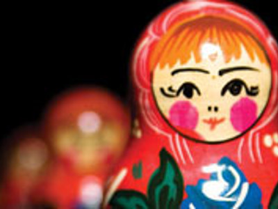 Close-up van een Russische matroesjka-pop met rood hoofddoekje en bloemenmotief.