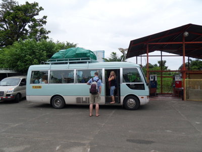 Minibus met bagage op het dak bij een tankstation in Costa Rica.