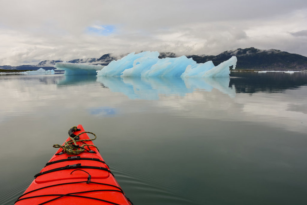 Rode kajak op rustig water met drijvende ijsbergen in Spitsbergen.