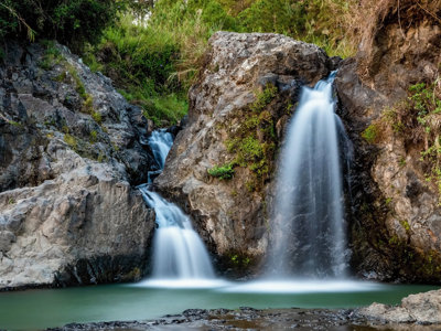 Waterval tussen rotsen met groen in de Filipijnen, onderdeel van de route Filipijnen.