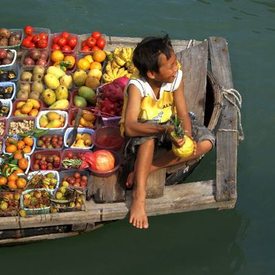 Fruitverkoper op een boot bij de drijvende markt in Vietnam tijdens een groepsrondreis.