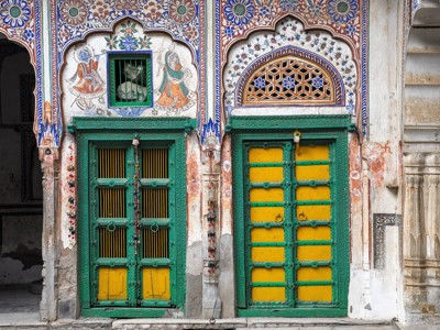 Beschilderde gevel met kleurrijke deuren en muurschilderingen in Rajasthan tijdens de Route Rajasthan & Gujarat, 20 dagen.