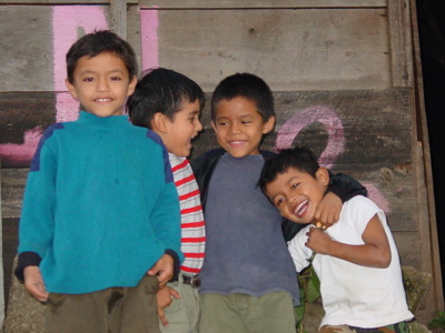 Lachende kinderen poseren voor een houten muur tijdens de Route Nicaragua, 23 dagen.